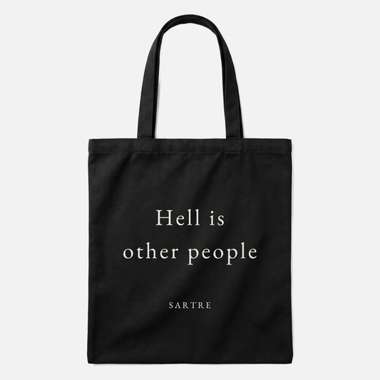 Sartre quote tote bag by Subtext – cream text on a black canvas tote with zip closure, front view.