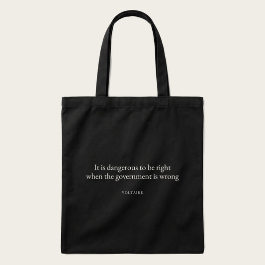 Voltaire quote tote bag by Subtext – cream text on a black canvas tote with zip closure, front view.